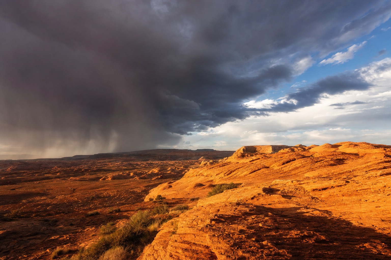 Storm clouds and sun sharing the sky over orange sandstone desert outside Page, Arizona