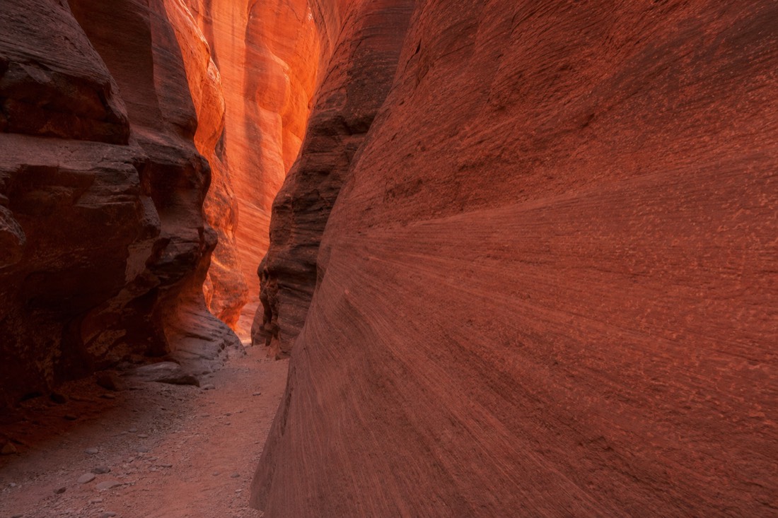 Soft orange and red reflected light on smooth canyon walls with no direct sunbeam