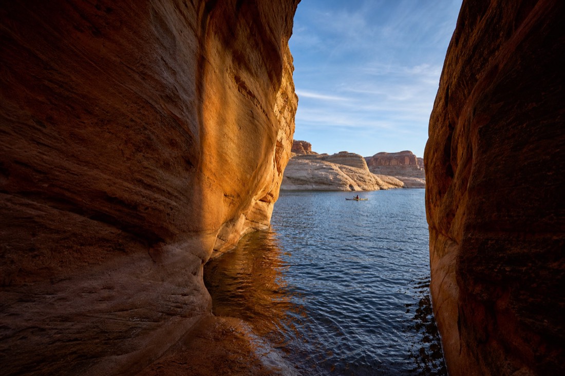 Split scene of narrow glowing slot walls beside open blue lake water and paddlers