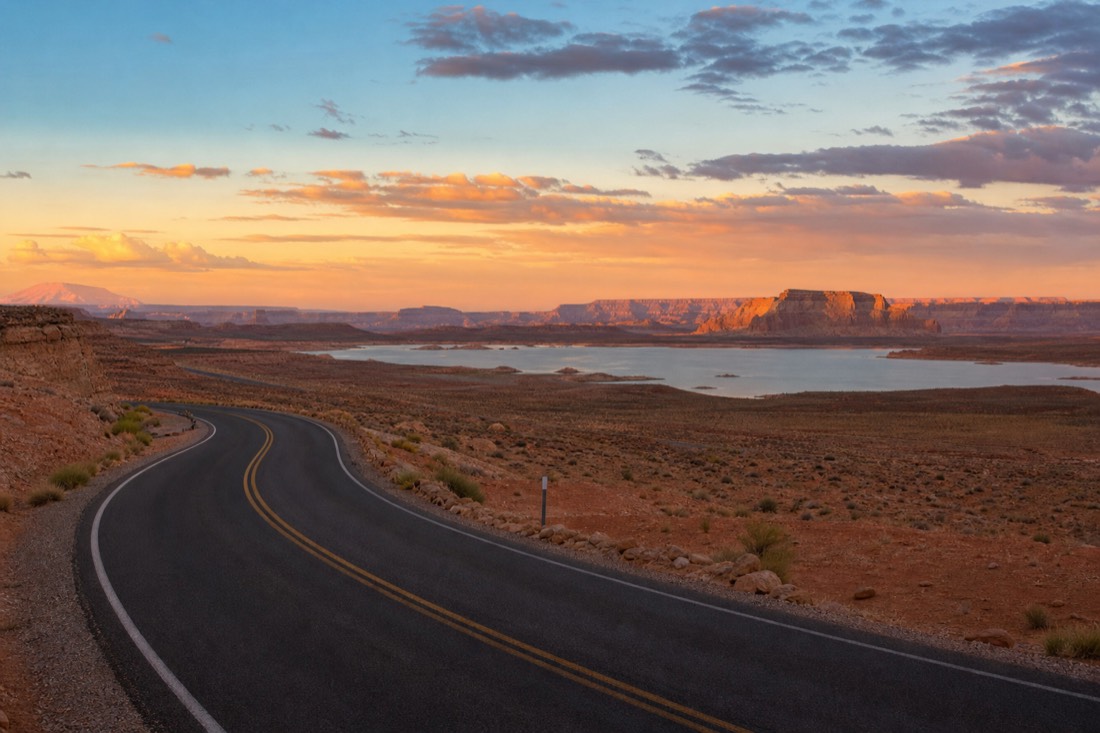 Sunset over Lake Powell near Page with a road curving toward distant cliffs