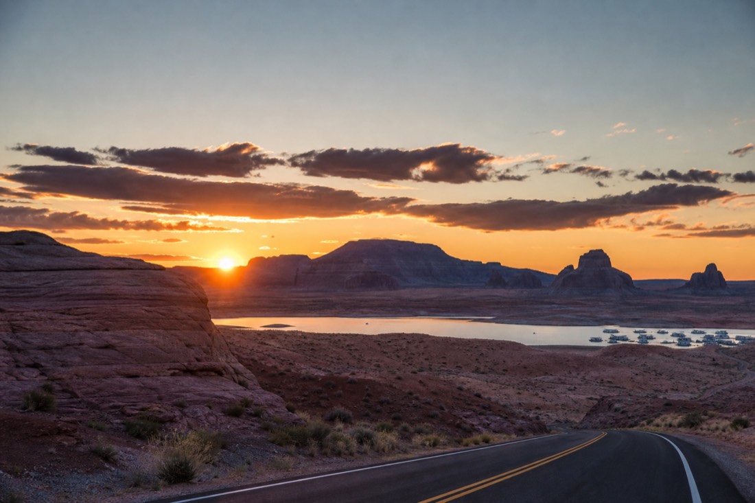 Sunset over Lake Powell and desert buttes near Page Arizona with a road in the foreground