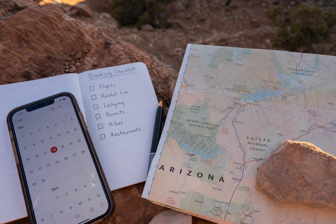 Phone calendar and booking checklist beside a map of northern Arizona canyon country